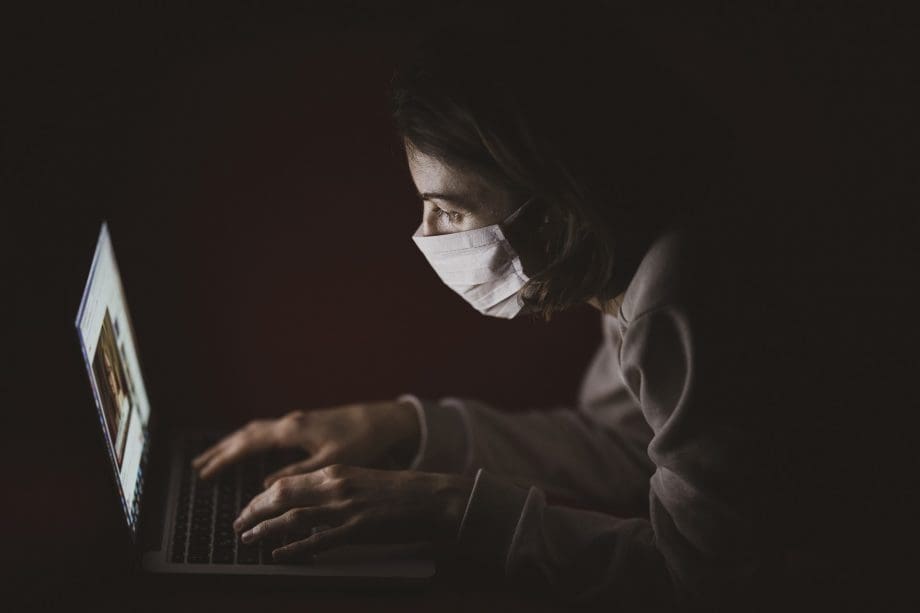 Frau mit PC und Maske